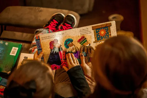 Children gathered around an open illustrated picture book