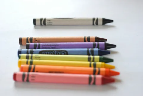 Stack of colorful crayons on a white surface
