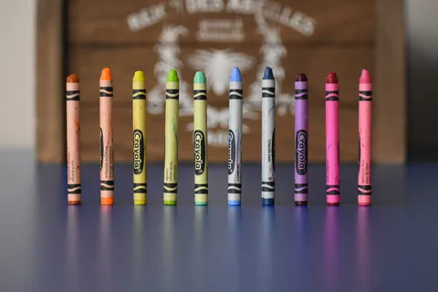 Row of upright crayons on a blue table