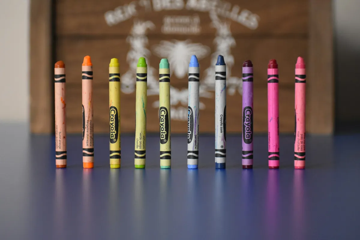 Row of upright crayons on a blue table