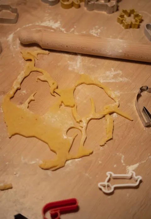 Cookie dough with animal-shaped cutters on a wooden table