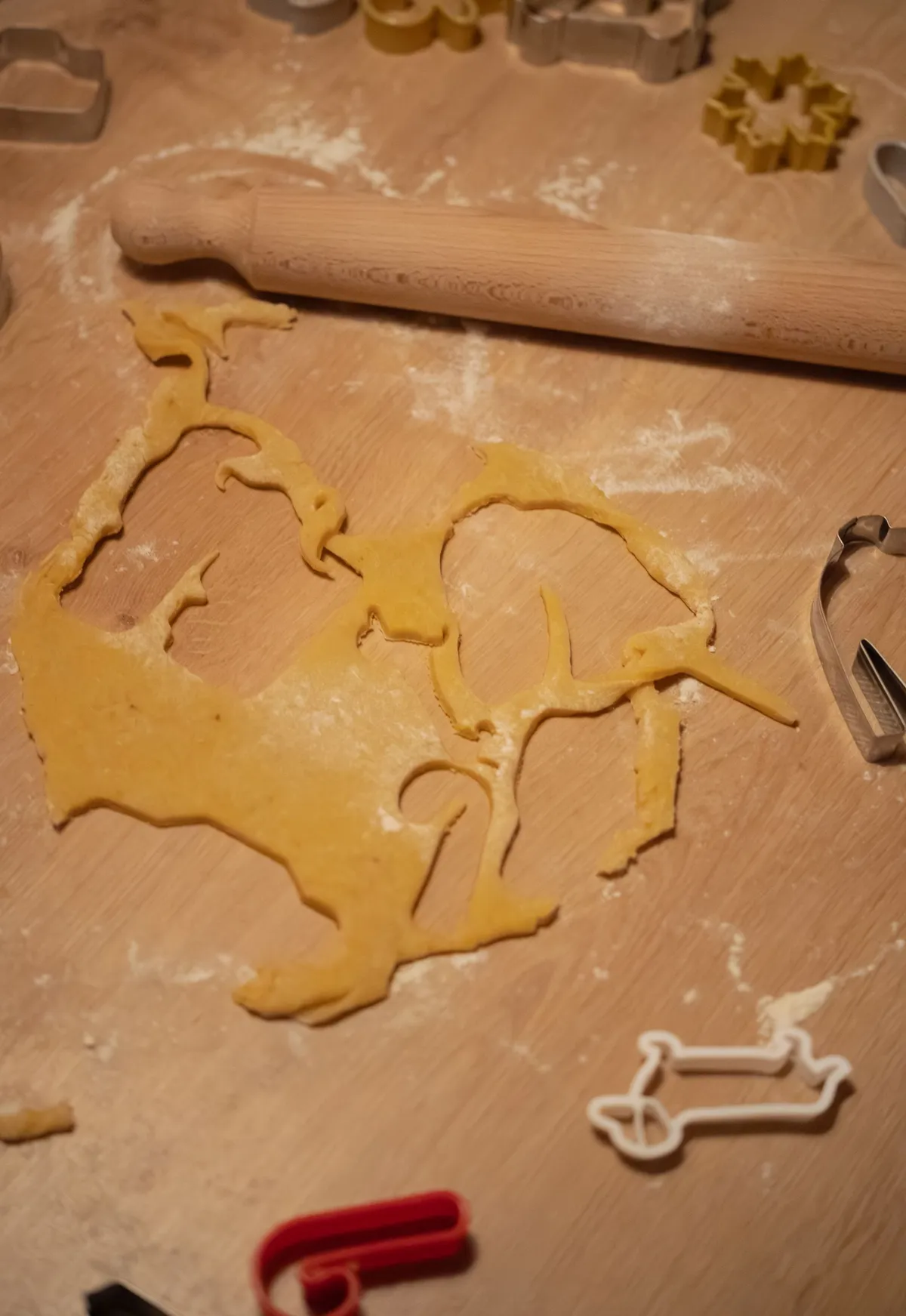 Cookie dough with animal-shaped cutters on a wooden table