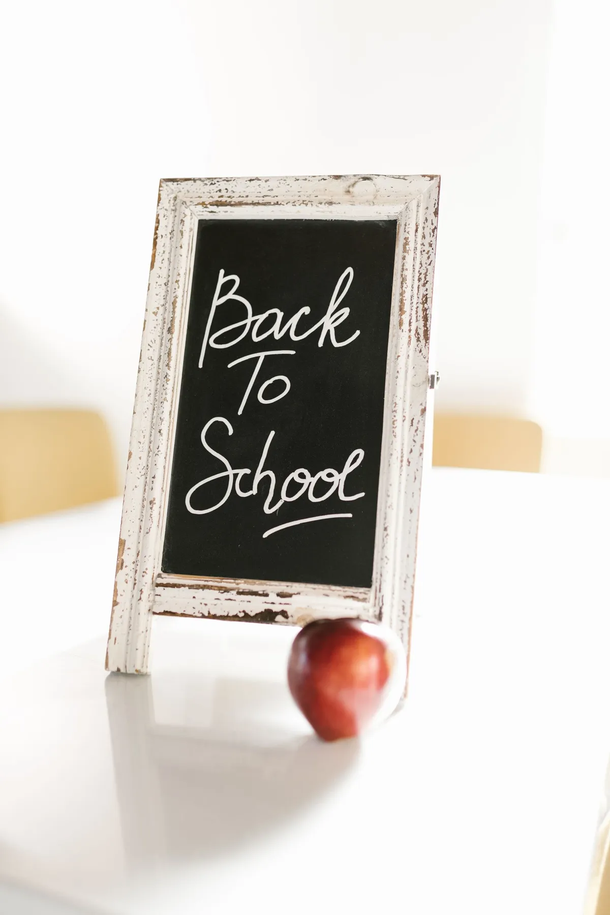 A chalkboard reading Back to School beside a red apple