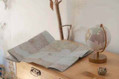 A vintage map and globe on a wooden table