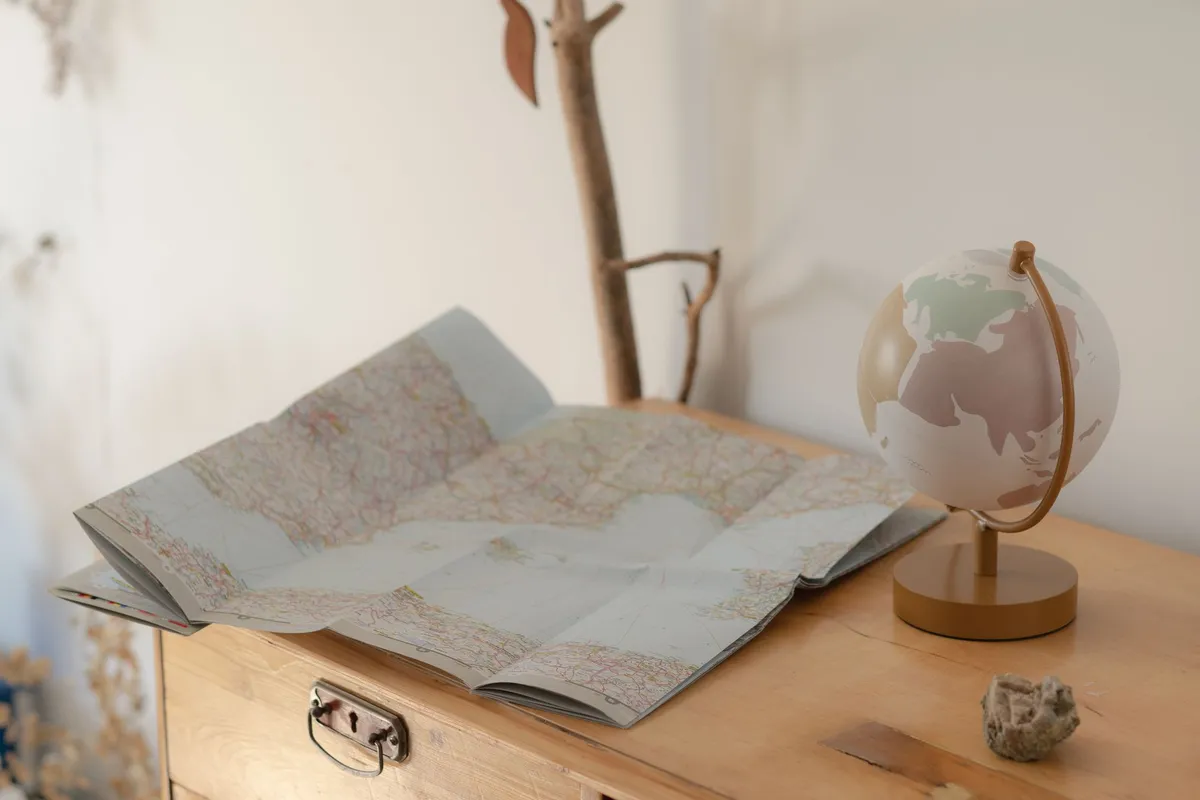 A vintage map and globe on a wooden table