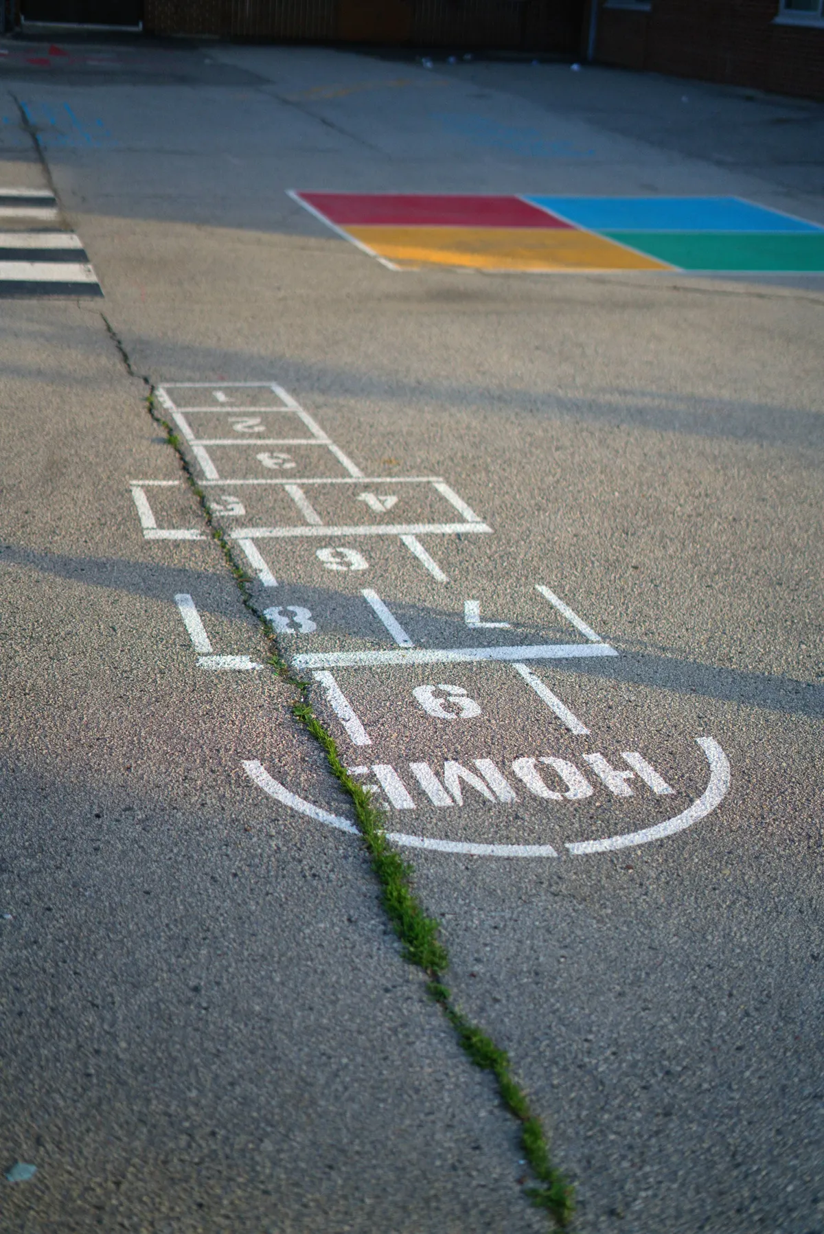 A colorful hopscotch pattern painted on a sunlit playground