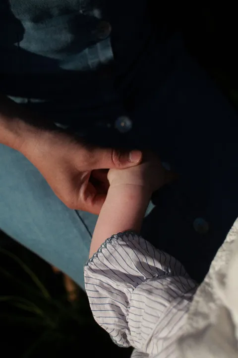 Close-up of a child's hand held by a parent