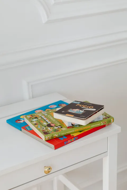 Children's books stacked on a white table