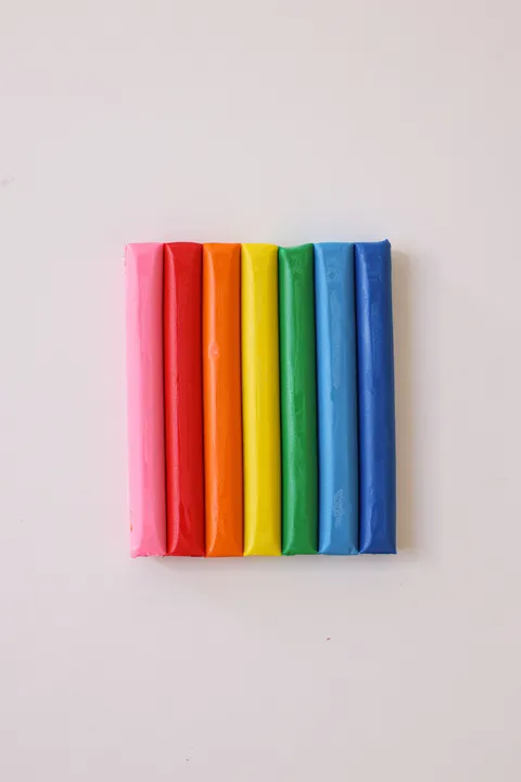 Colorful modeling clay bars arranged neatly on a white background