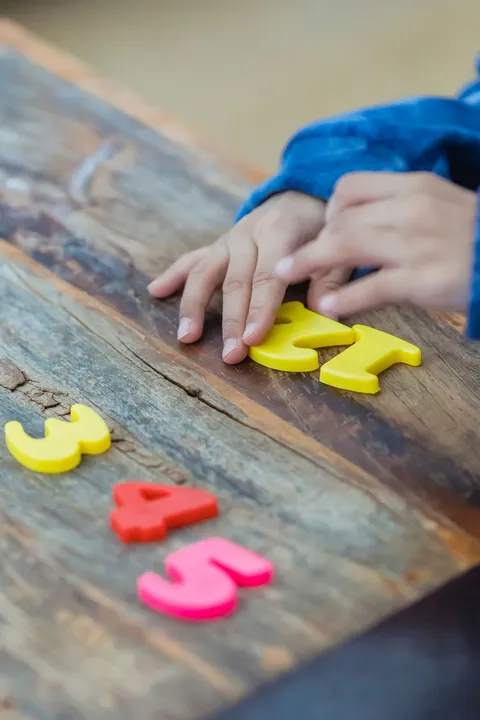 A child counting colorful numbers, seen from above