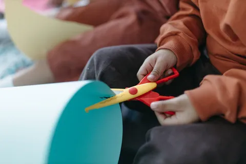 Children using colorful scissors to cut paper