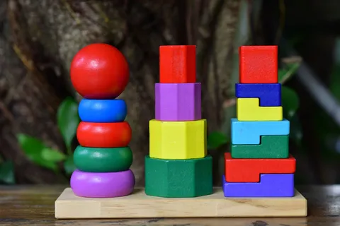 A bright wooden stacking toy set on a wooden base