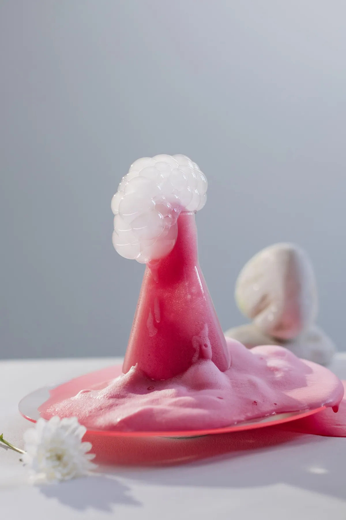 Pink foaming liquid erupting from a glass flask