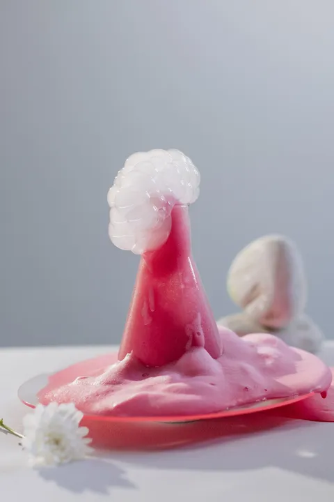 Pink foaming liquid erupting from a glass flask