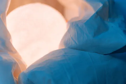 An illuminated moon lamp wrapped in soft cloud-like fabric